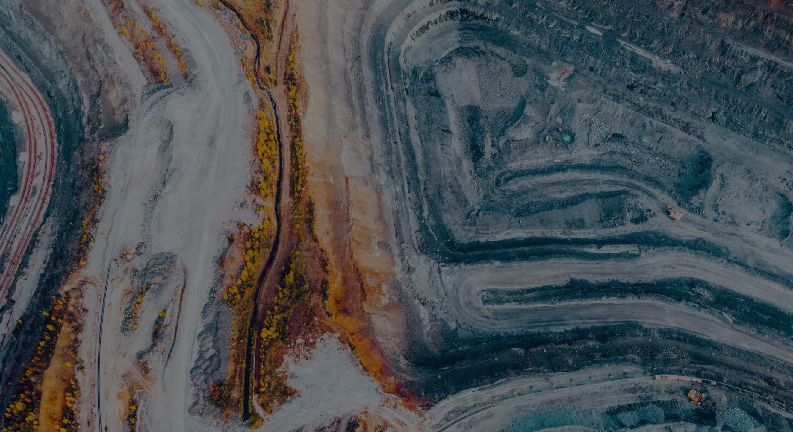 Vista aérea de un sitio de trabajo minero a cielo abierto sitio de trabajo caminos de excavación en terrazas y equipos de construcción dispersos.