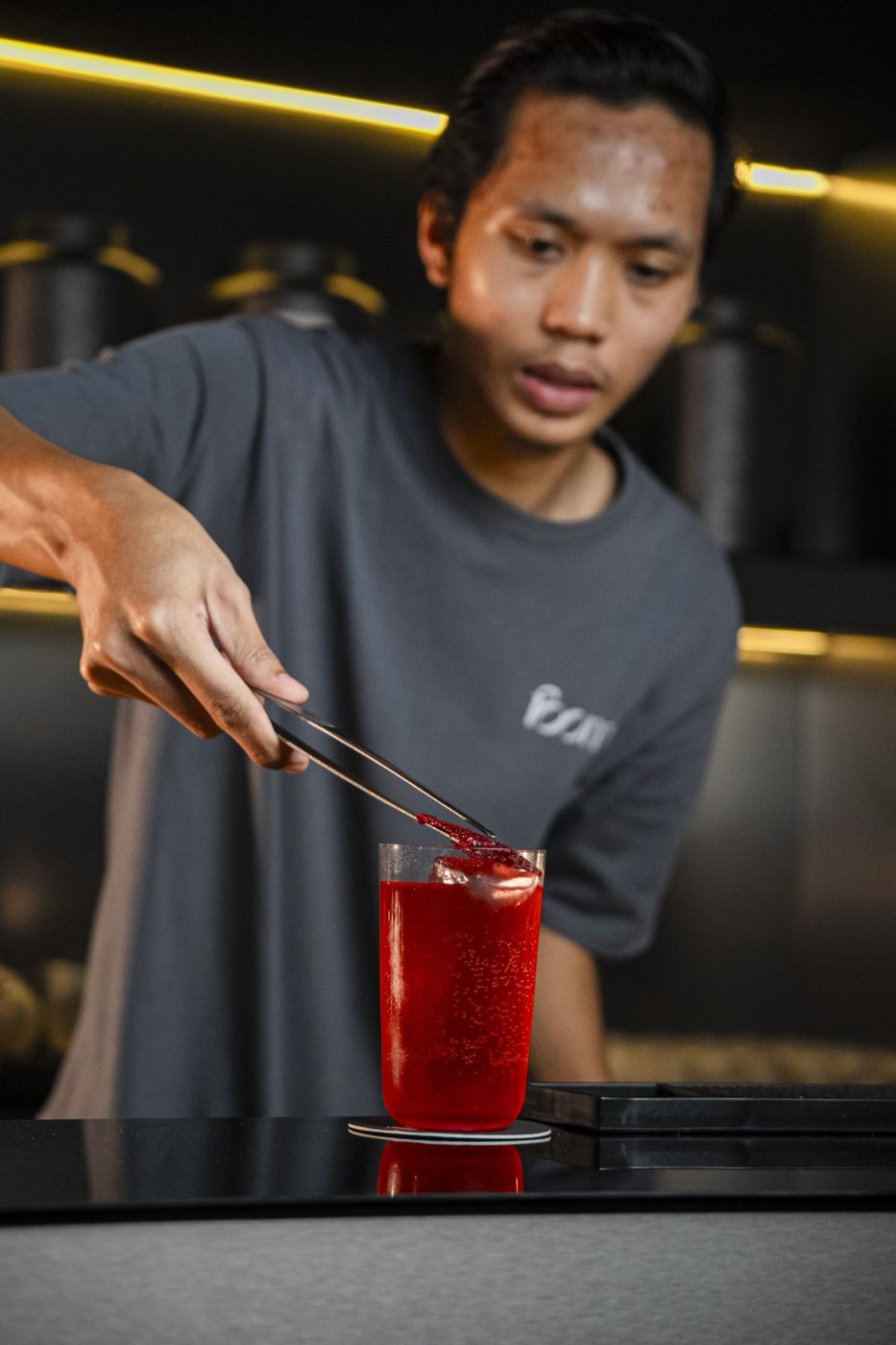A bartender garnishing a red cocktail at FOOM, Johor Bahru
