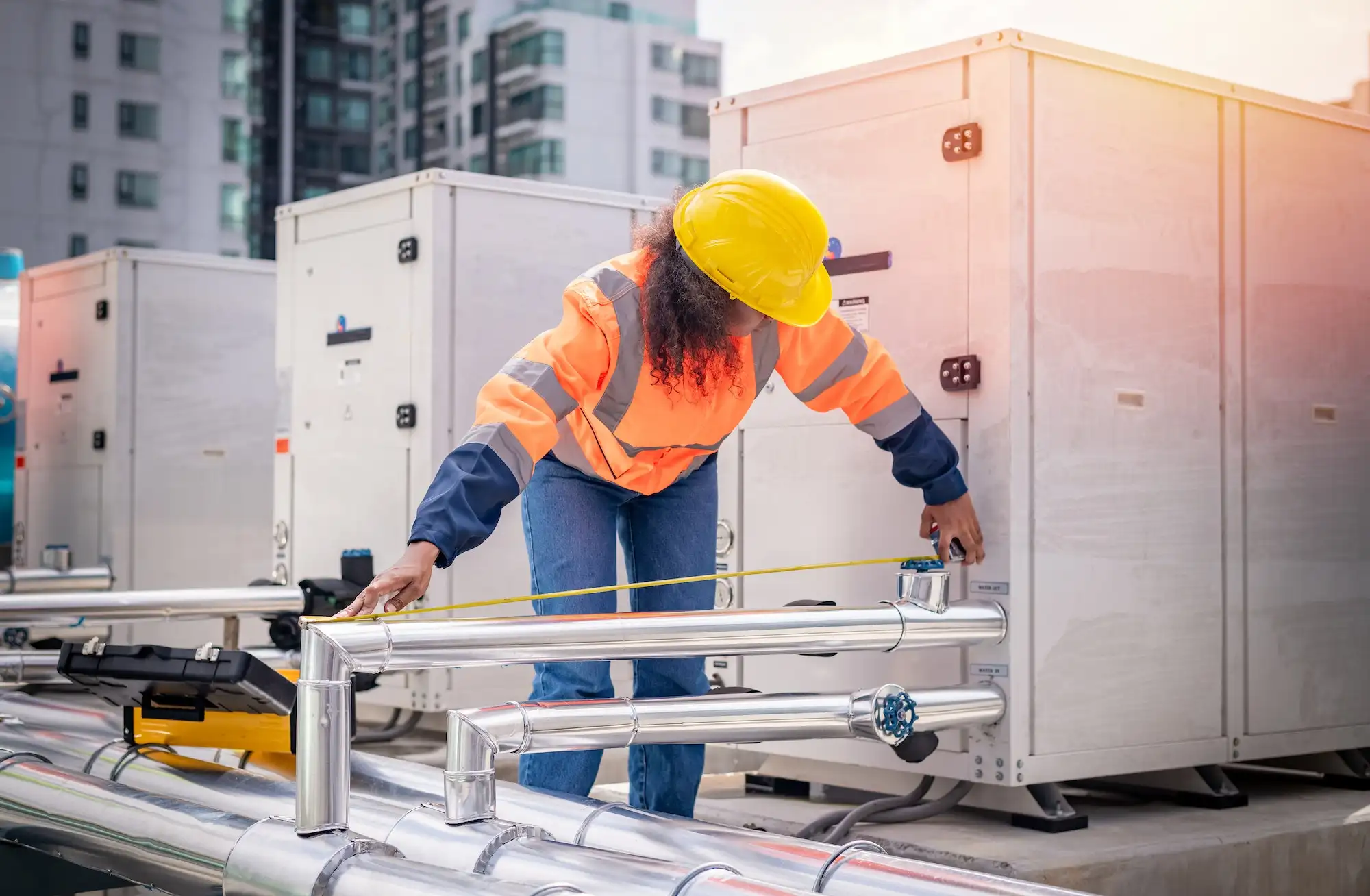 Technician measuring pipe for HVAC retrofit.