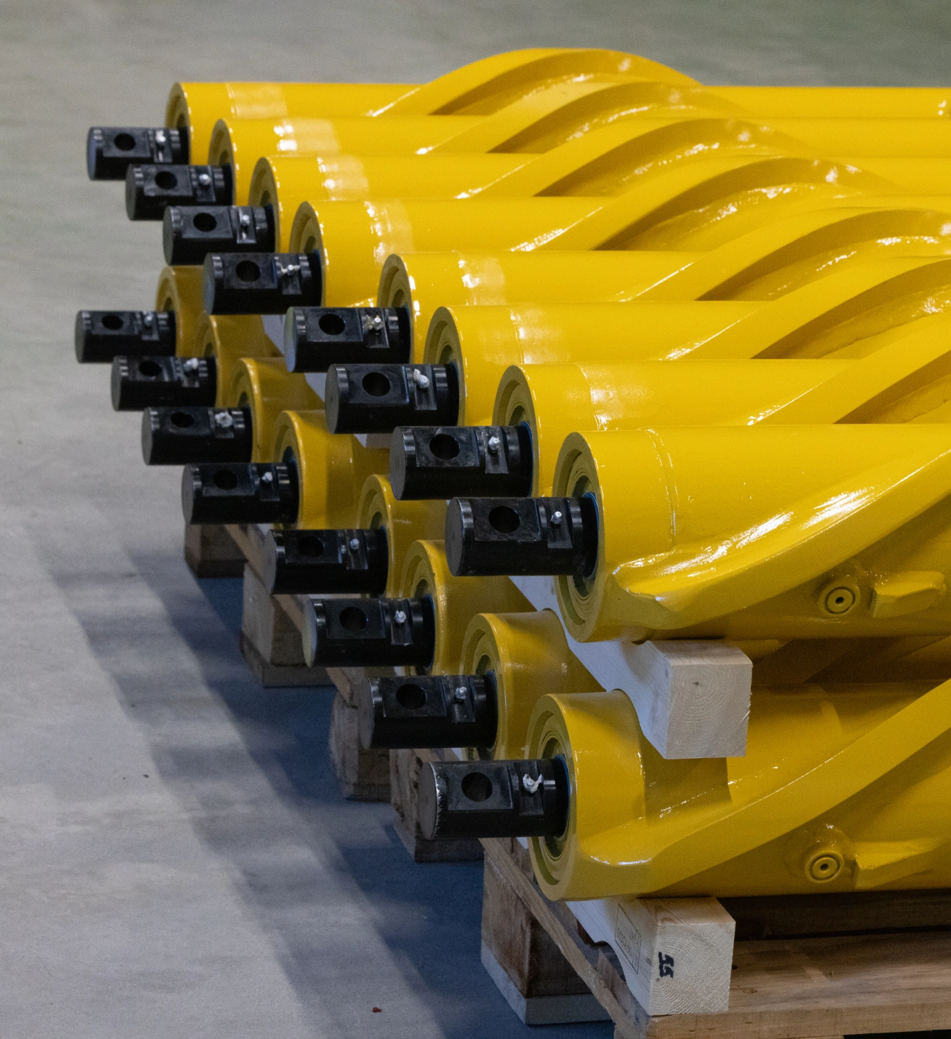 Row of yellow spiral brakes mounted on rails during manufacturing at Decel's factory.
