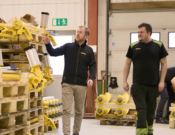 DECEL employees in the warehouse among pallets of yellow spiral brakes