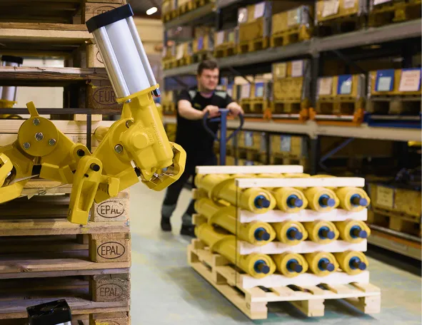Warehouse worker moving a pallet of yellow DECEL spiral brakes with a pallet jack