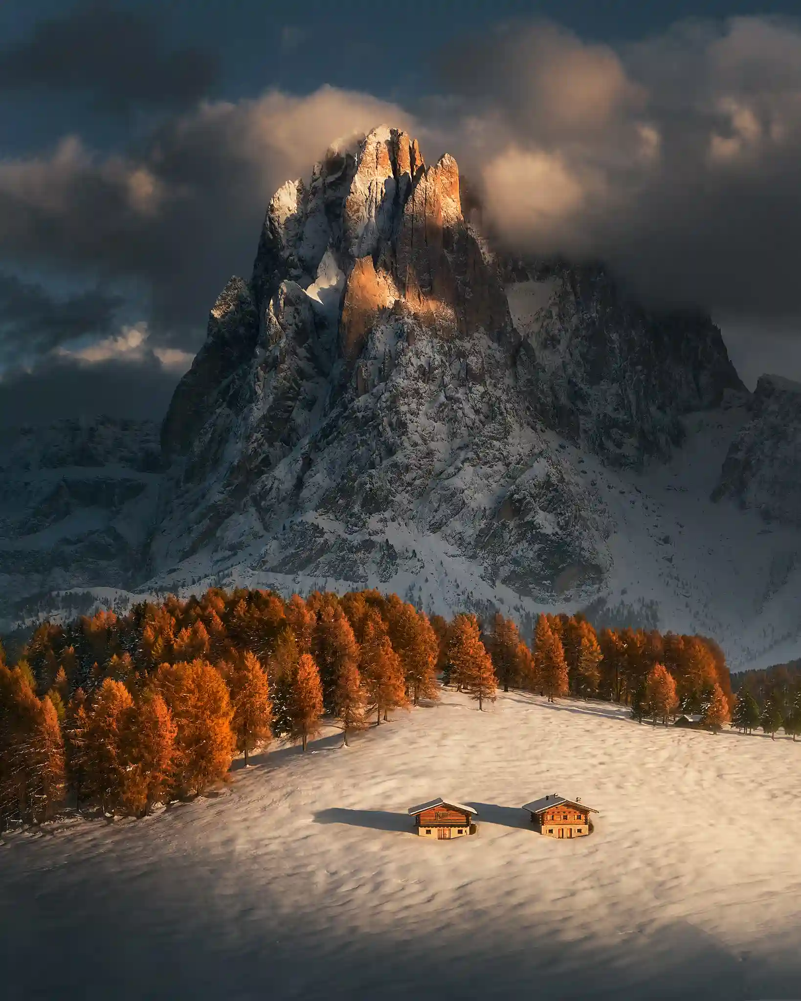 Paisaje de montaña iluminado por luz cálida entre nubes