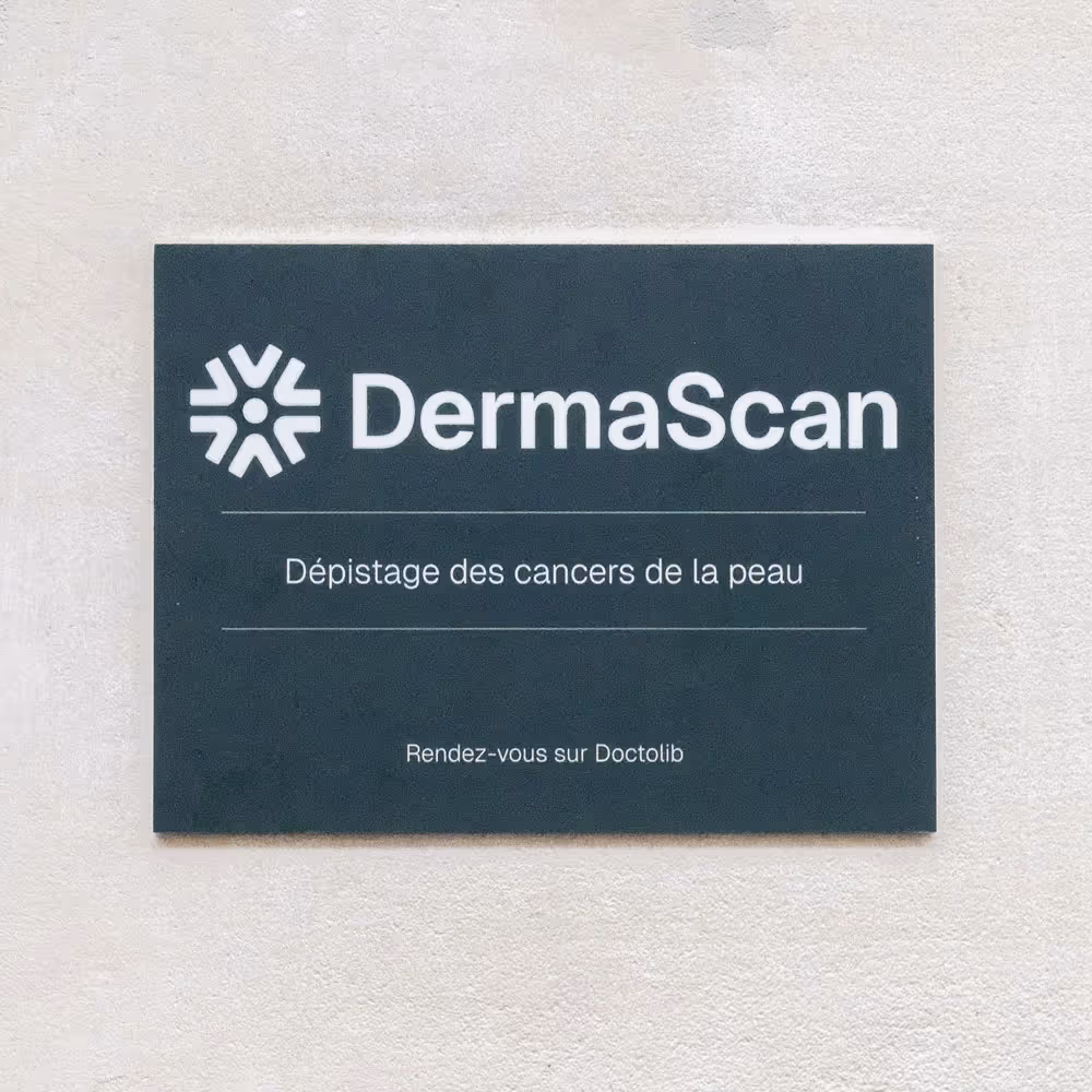 Panneau noir avec logo et texte blanc : DermaScan, dépistage des cancers de la peau, rendez-vous sur Doctolib.