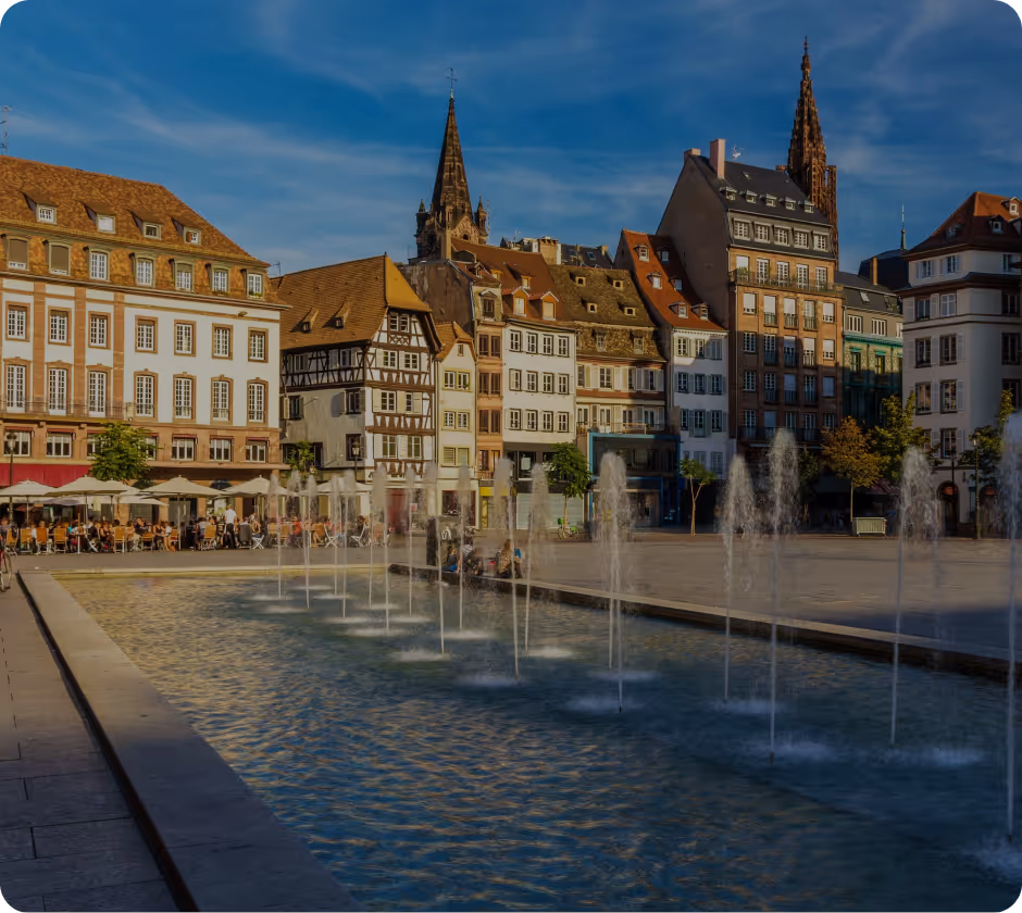 Vue de Nantes avec la Loire en avant-plan, un bateau blanc amarré, des bâtiments historiques et une grande coupole à droite.