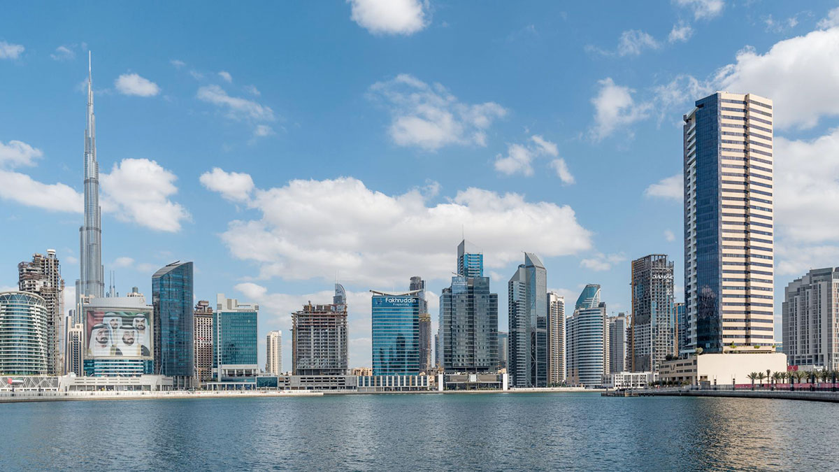 Dubai Business Bay waterfront skyline with Burj Khalifa and high-rise towers across the canal.