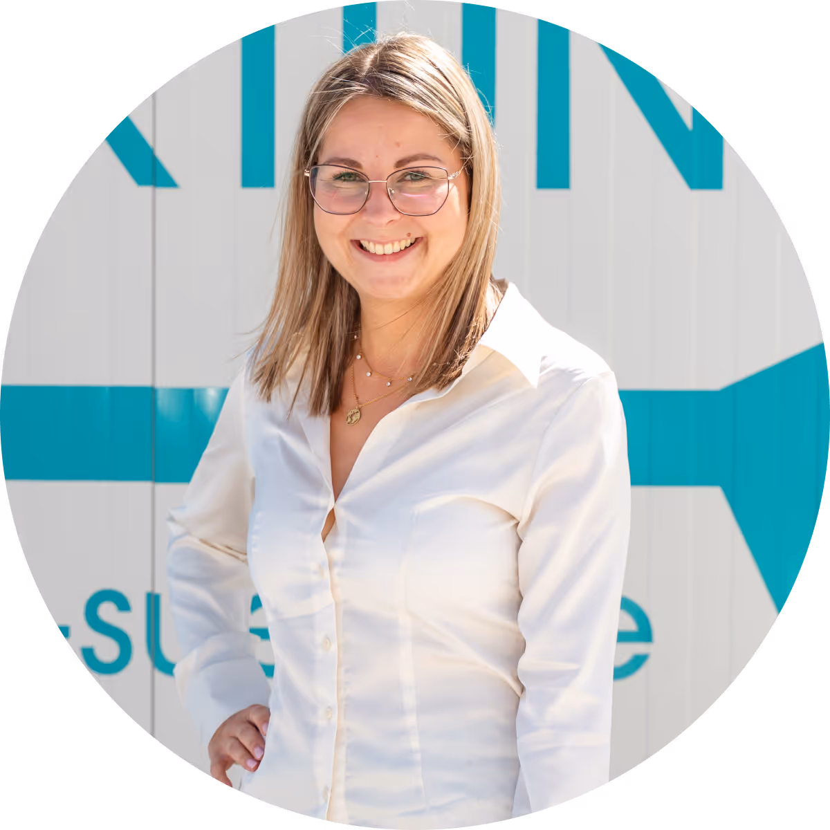 Lächelnde Frau mit Brille und weißer Bluse vor grauer Wand mit blauem Pfeil und Text.