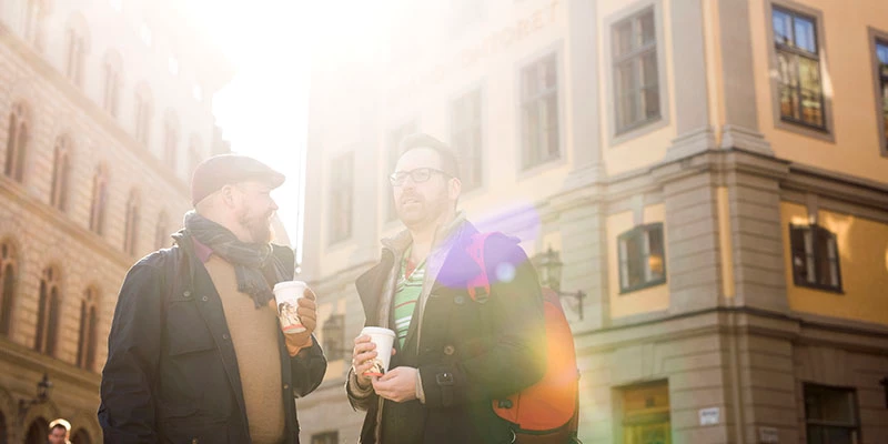 to mænd står på gaden i sollys