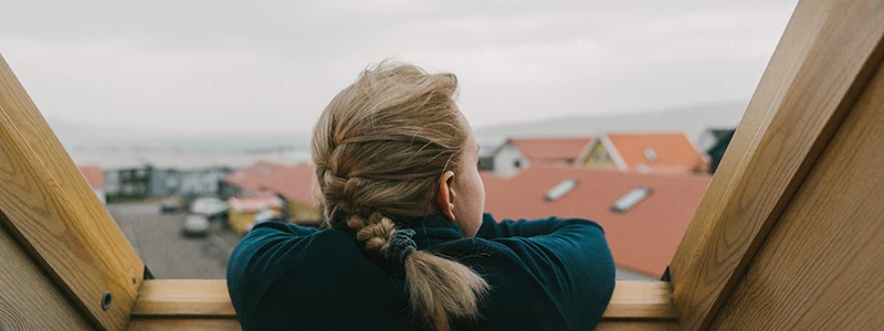 Ung dame skurer ud af sit loftsvindue