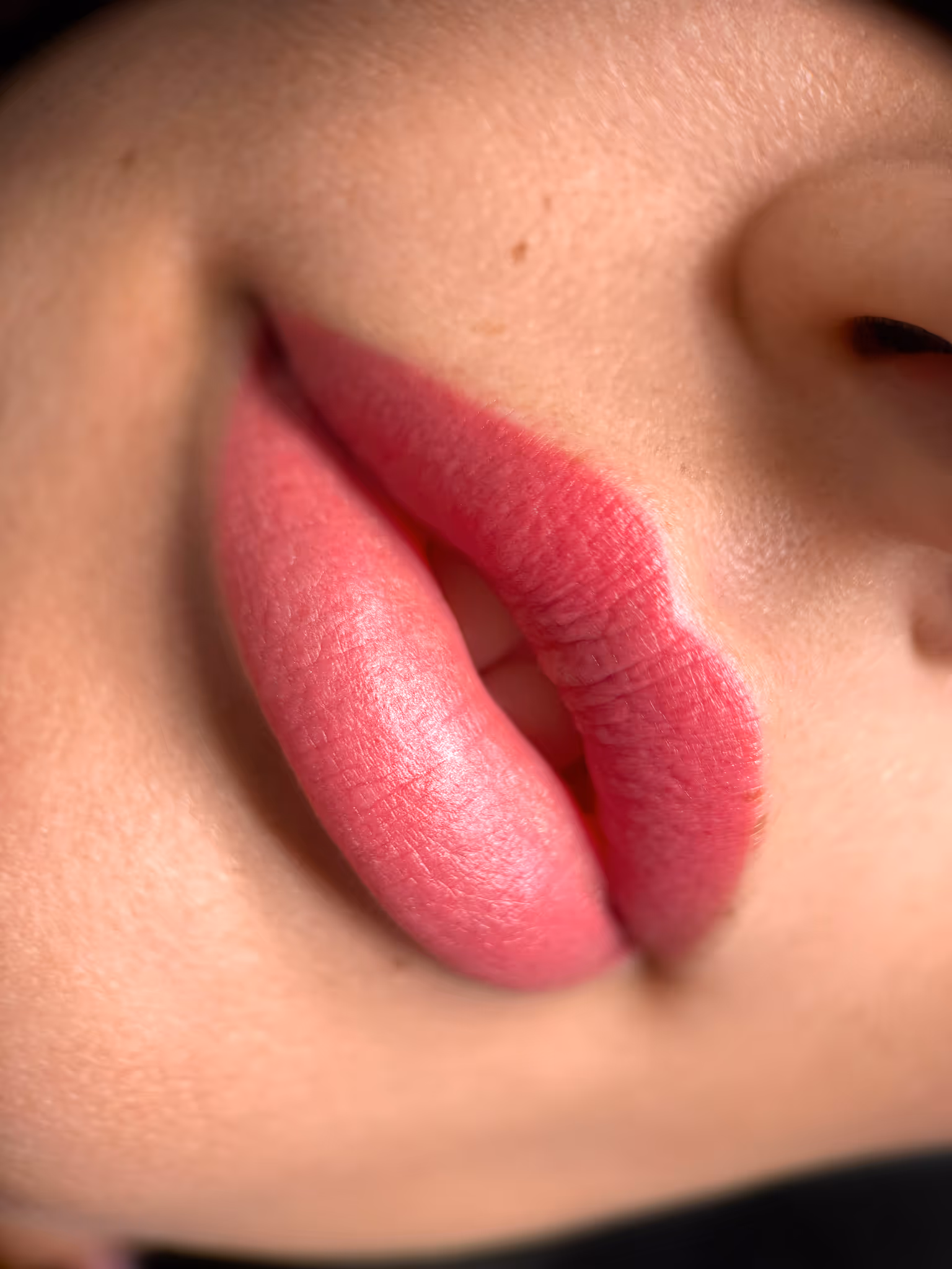 Zbliżenie na usta pokryte różową szminką.