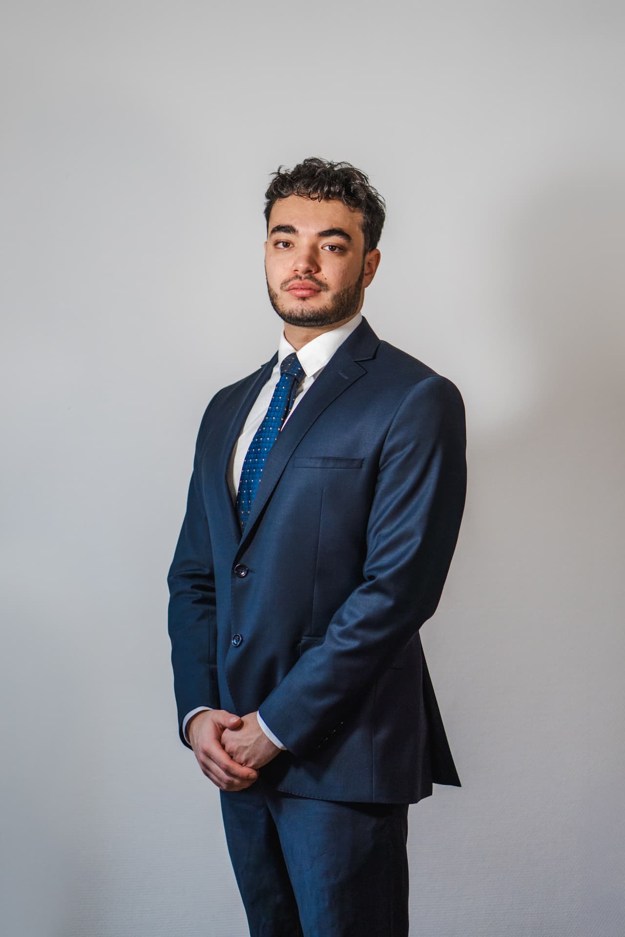 Homme d'affaires mûr en costume travaillant sur un ordinateur portable avec un carnet et une tasse de café sur une table en marbre devant une fenêtre avec balcon.