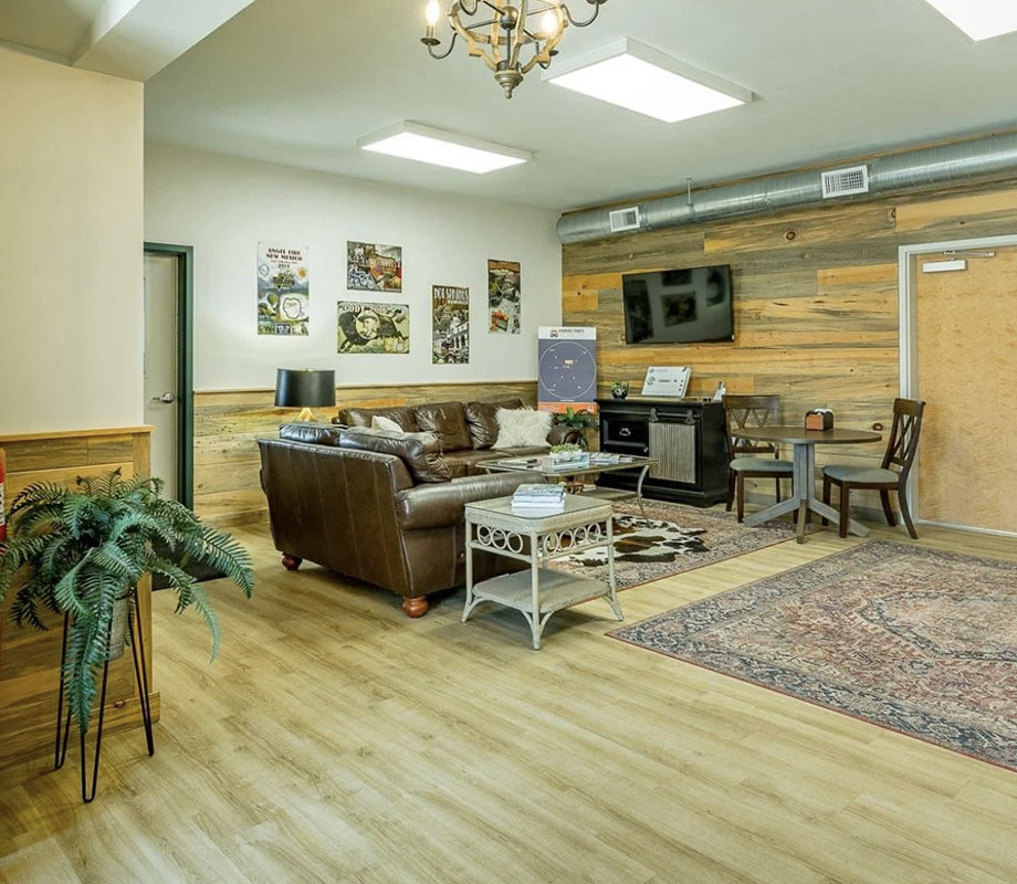 The comfortable guest lounge with leather seating and rustic wood accents.