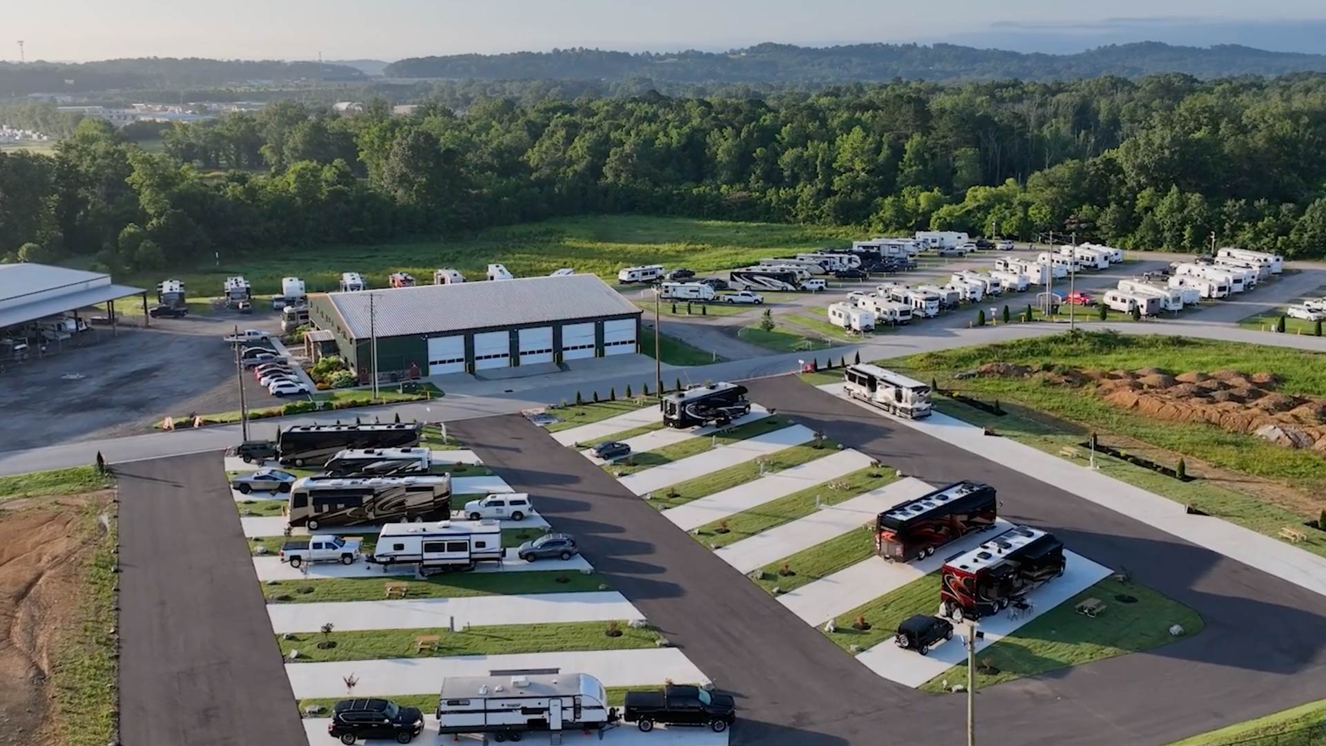 Aerial view of a Hawkins Pointe RV park with multiple motorhomes and trailers parked on paved lots surrounded by green trees and hills.