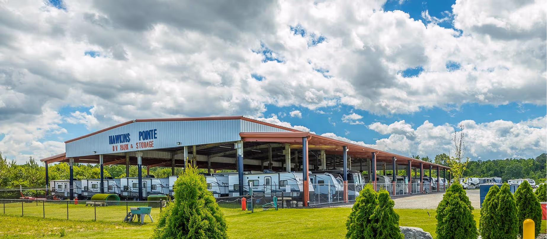 Our covered storage facility housing multiple RVs with the dog park in front.