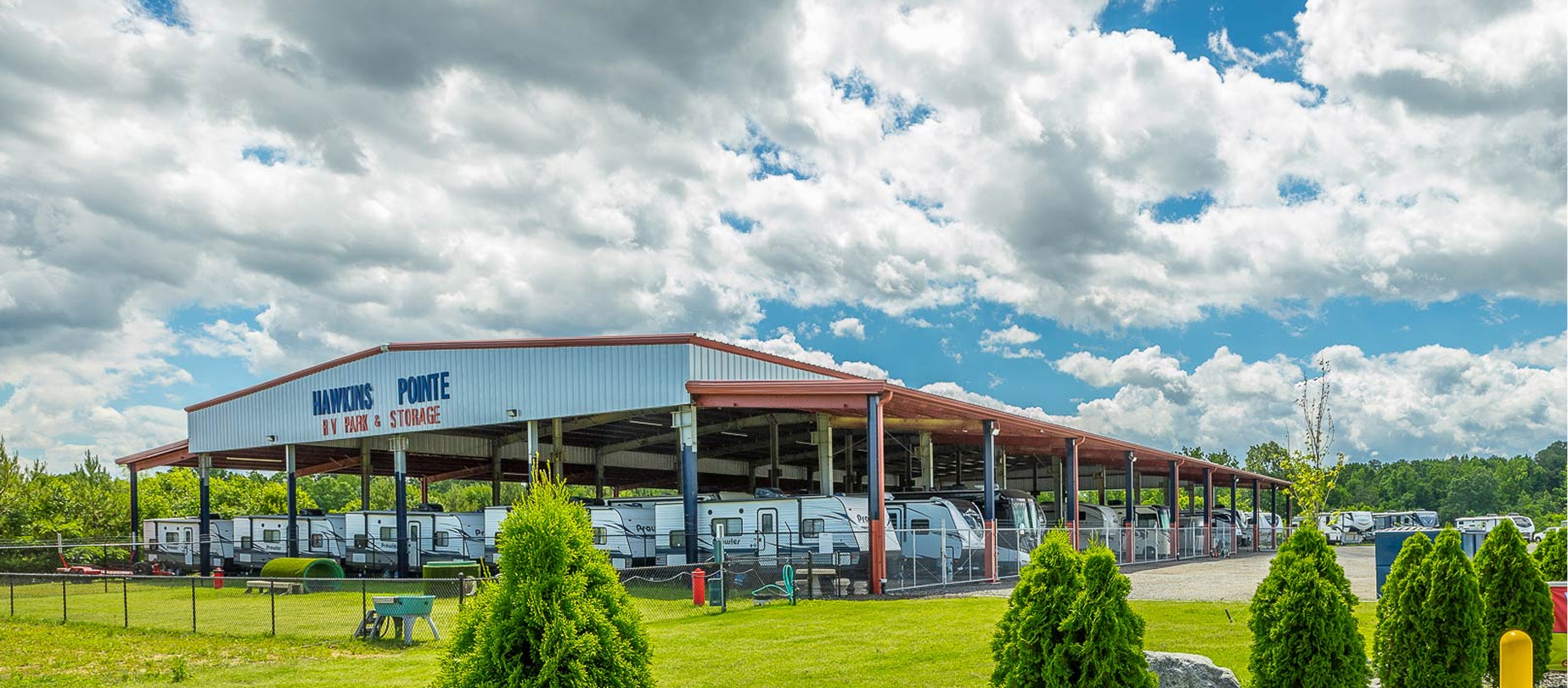 Our covered storage facility housing multiple RVs with the dog park in front.