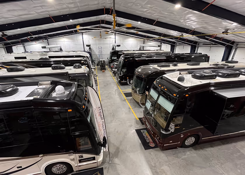  RV technician entering a motorhome with toolbox.