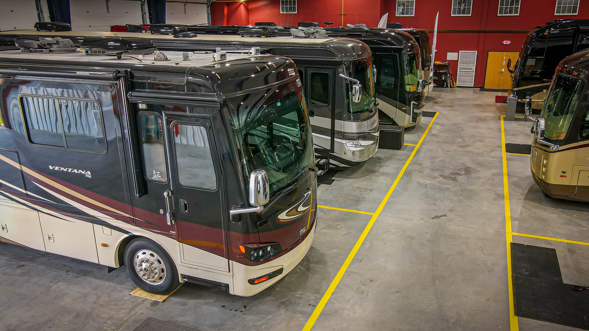 Inside our Luxury Storage facility with multiple motorhomes parked inside.