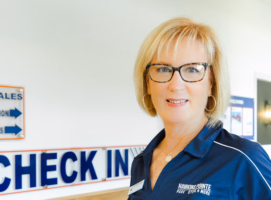 Karen Hawkins standing in front of Hakwins Pointe Check In sign.