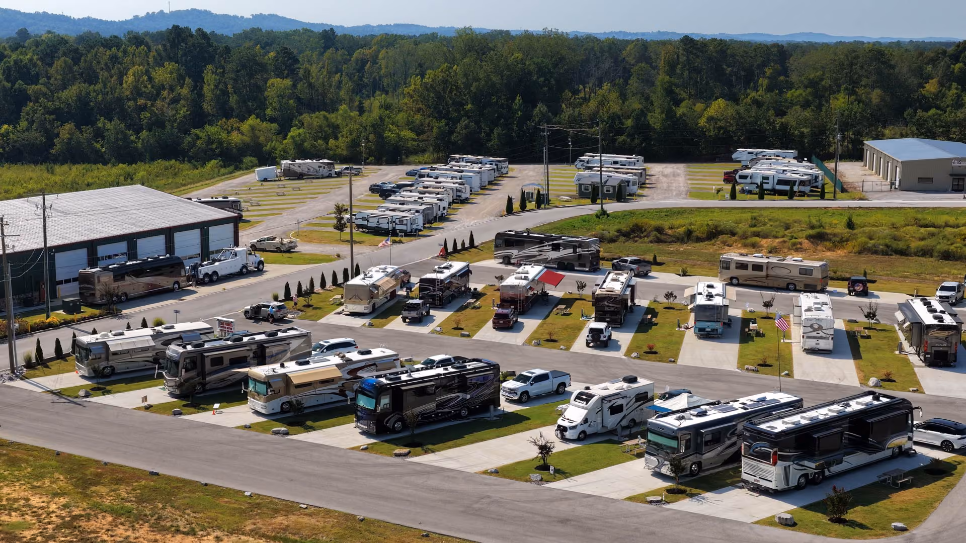 Aerial view of RVs parked in numbered sites at Hawkins Pointe RV Basecamp with the Appalachian foothills in the background.