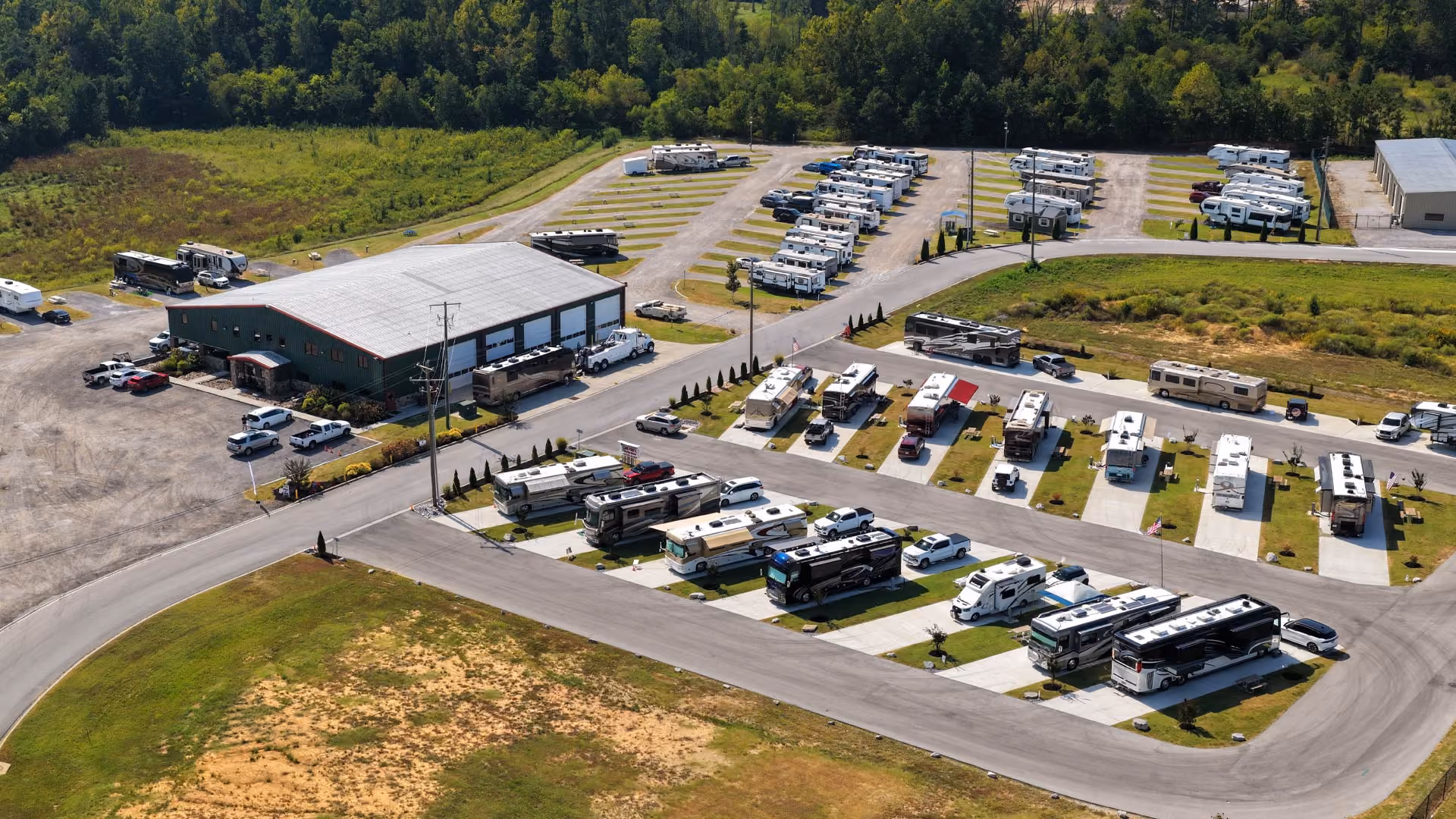 Aerial view of Hawkins Pointe RV Basecamp's service building and RV storage lot with motorhomes and travel trailers parked in landscaped rows.