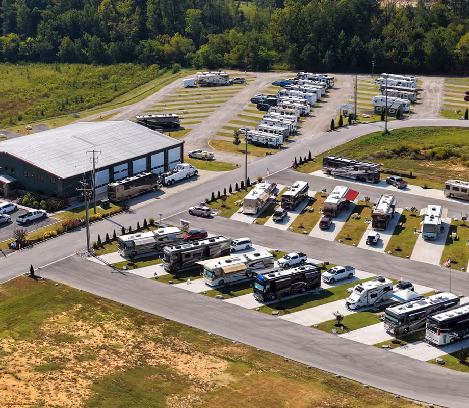 Aerial view of Hawkins Pointe RV Basecamp showing the main storage building, executive sites, and rows of RVs in background. 