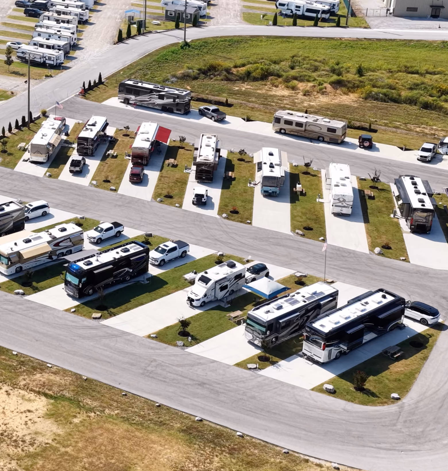 Aerial view of the Executive RV sites at Hawkins Pointe RV Basecamp with motorhomes parked on paved pads along a landscaped drive.