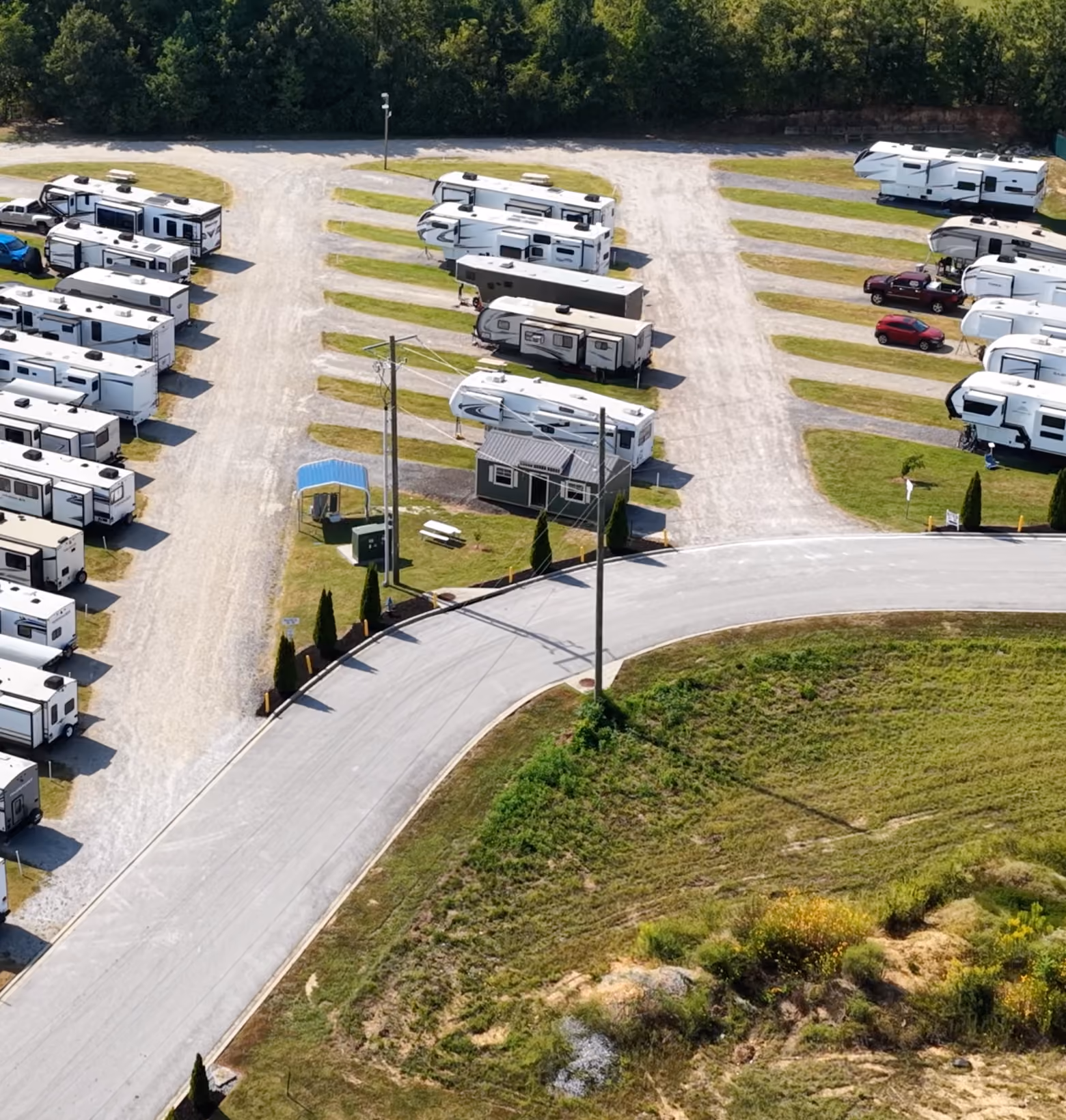Aerial view of the long-term RV storage area at Hawkins Pointe RV Basecamp with fifth-wheels and trailers parked in gravel rows.