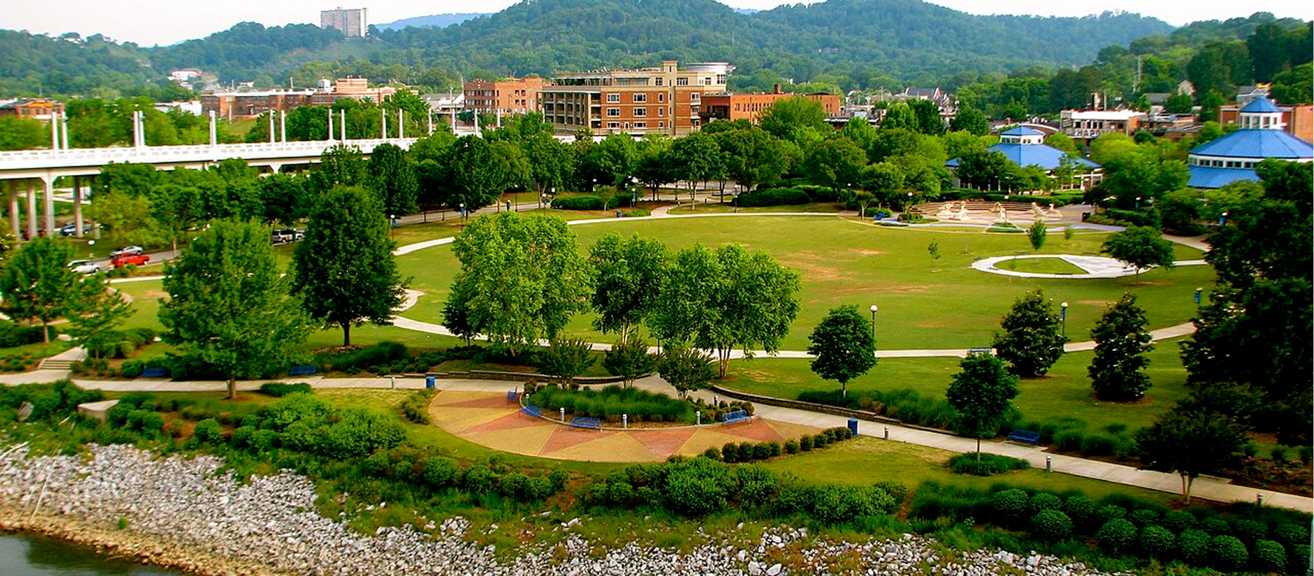Aerial view of the green lawn and riverfront at Coolidge Park in Chattanooga.