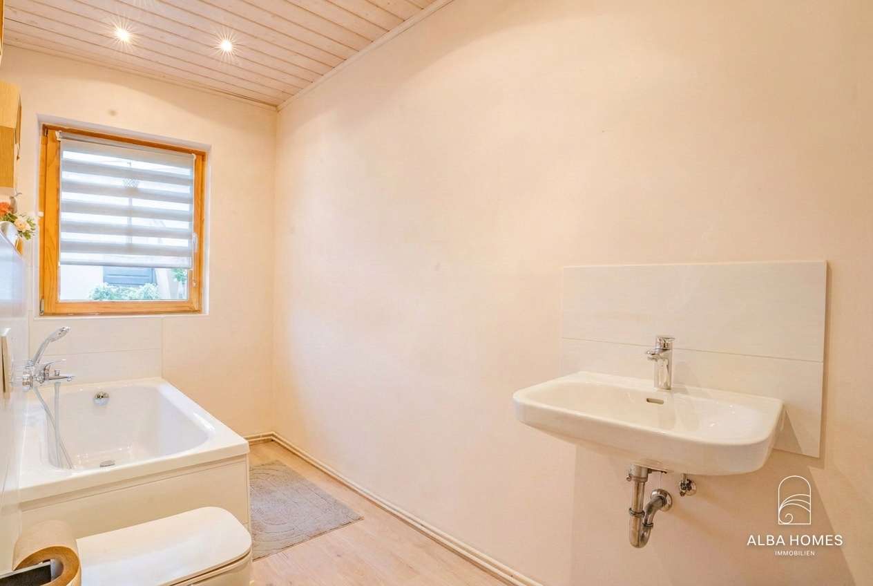 Tageslichtbad mit Badewanne und praktischer Ausstattung