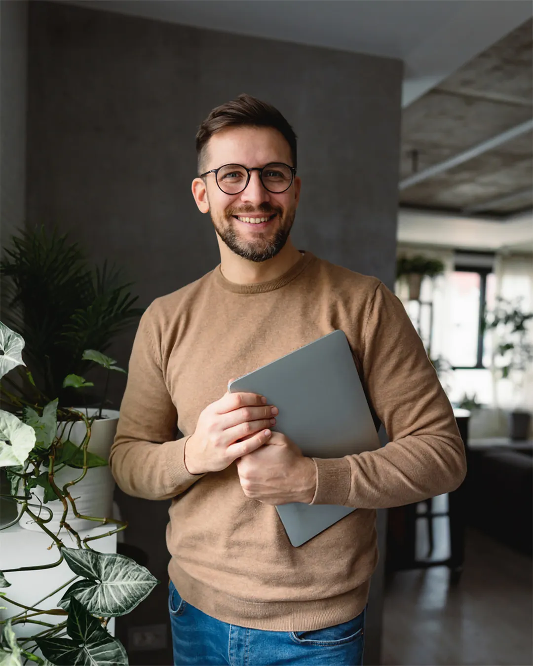 A man holding a laptop computer in his hands.