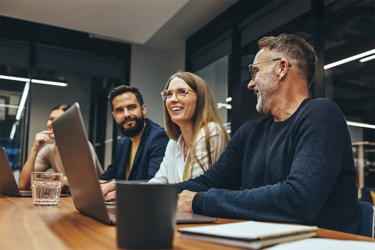 A group of people sitting around a wooden table.