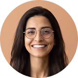 Smiling woman with glasses and long dark hair against a soft brown circular background.