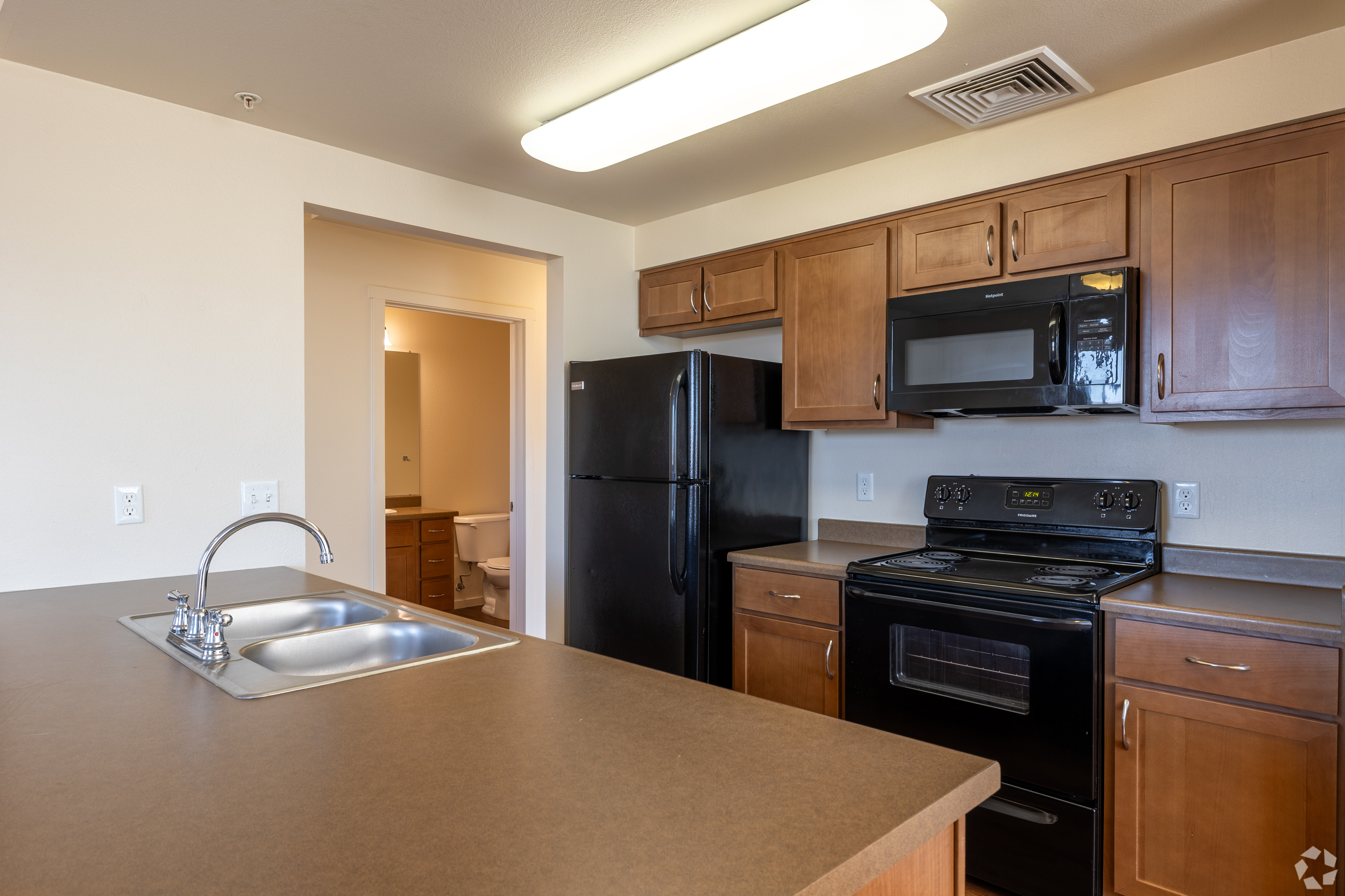 Kitchen with black appliances and brown cabinets