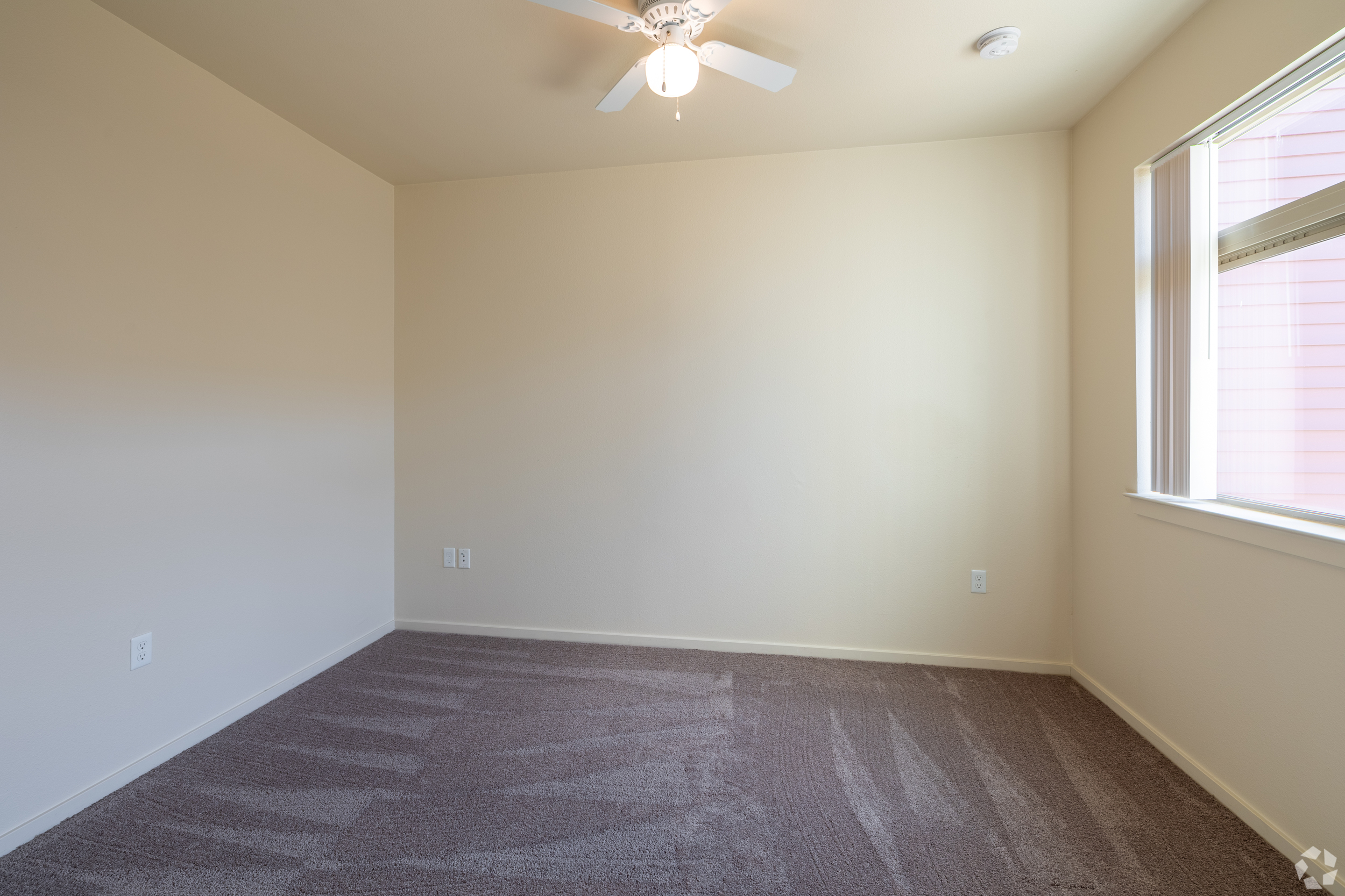 Unfurnished bedroom with a large window and carpet