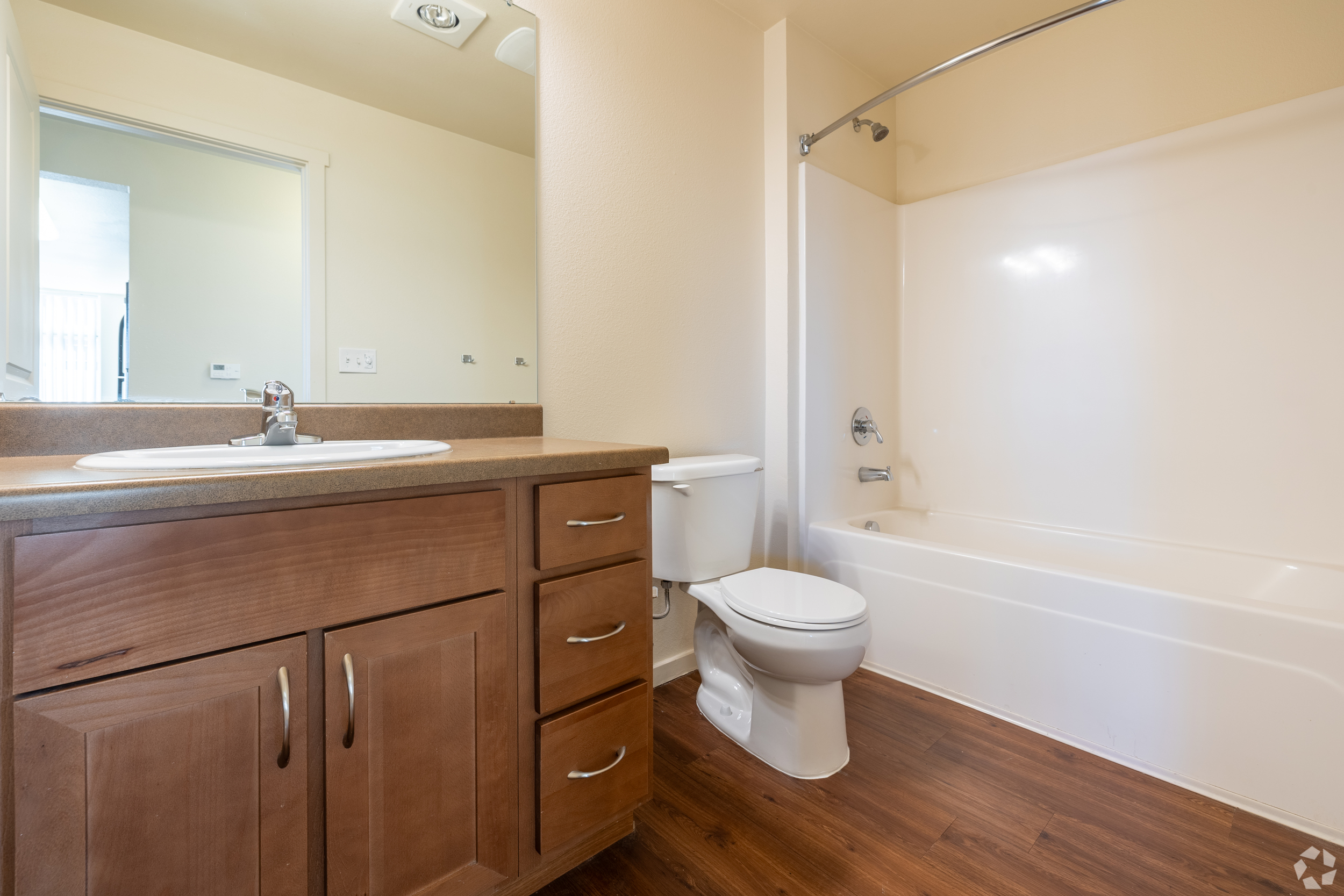 Bathroom with vanity, brown cabinets, and tub shower combo