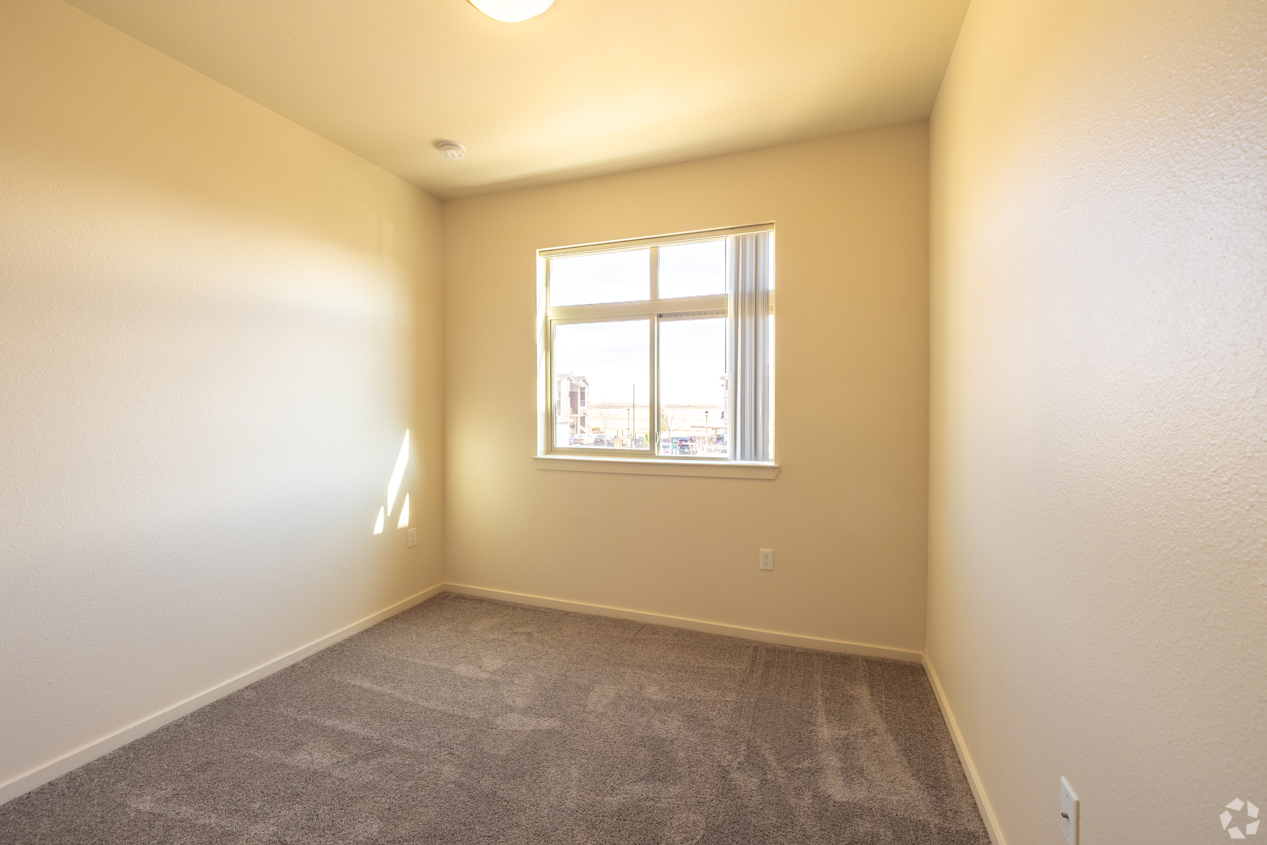 Unfurnished bedroom with a large window and carpet