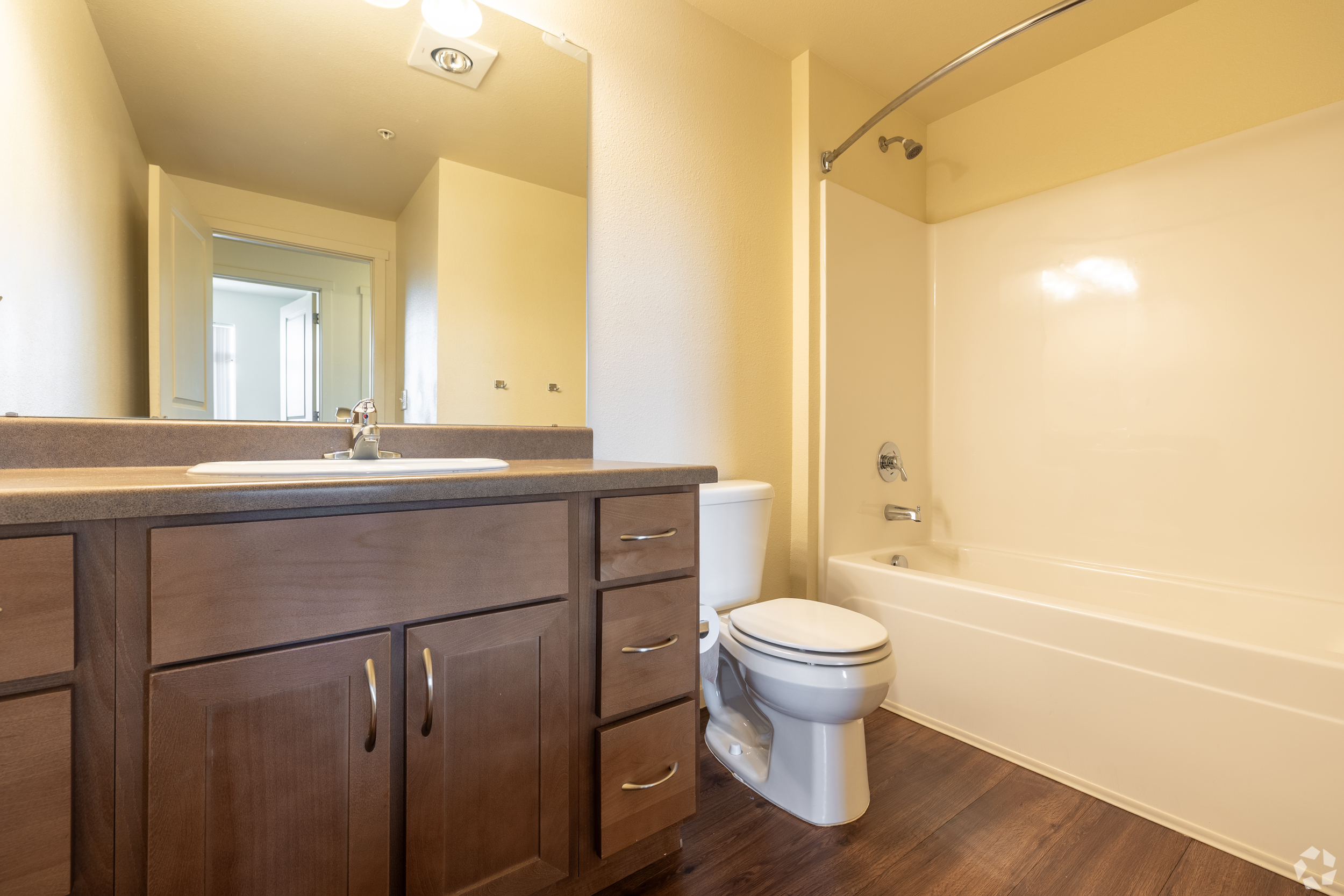 Bathroom with vanity, brown cabinets, and tub shower combo