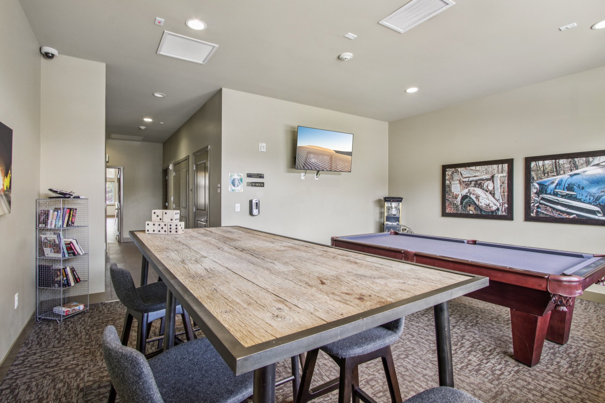 Clubhouse lounge with pool table, game table, television, and comfortable resident gathering area at Copper Peak Apartments.