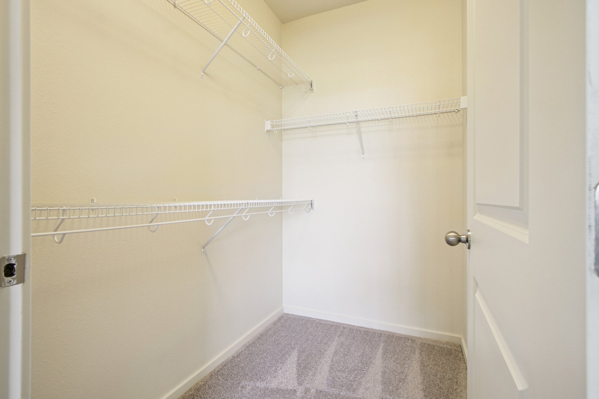 Large walk-in closet with built-in shelving and generous storage space in a Copper Peak apartment.