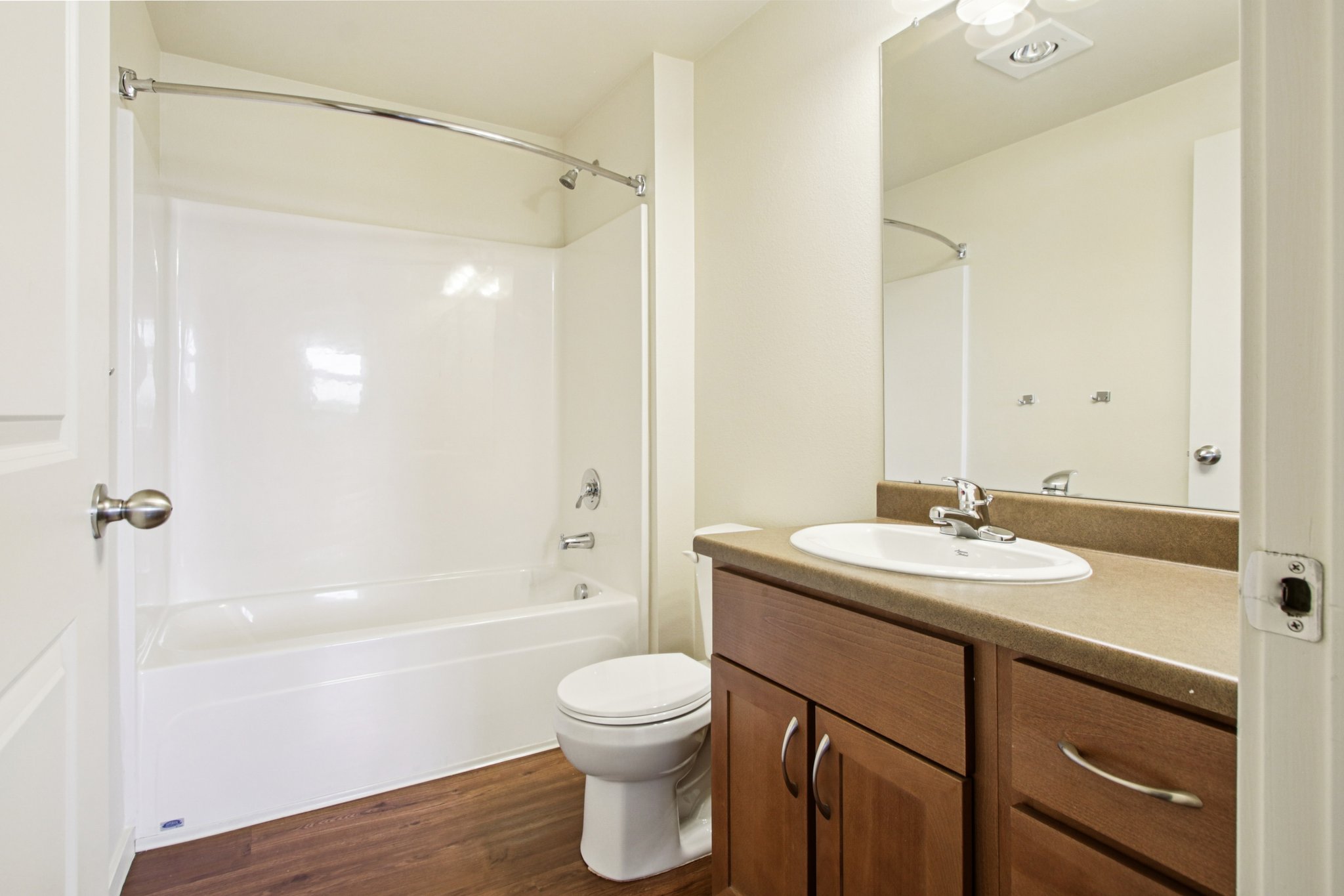 Secondary bathroom with vanity, bathtub and shower combination, and contemporary finishes at Copper Peak Apartments.