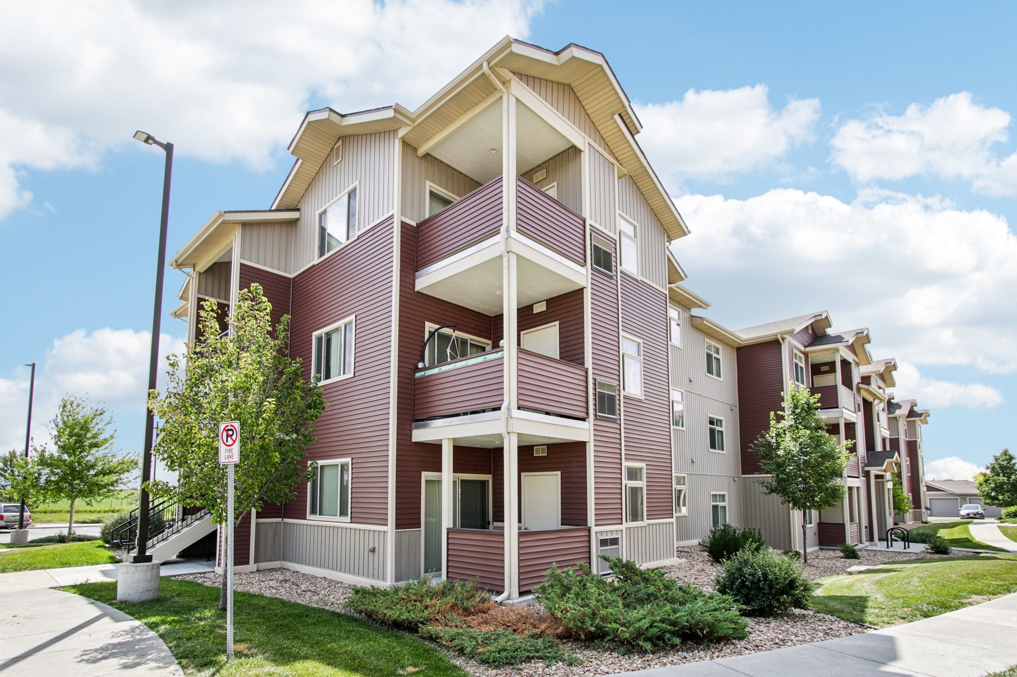 Exterior view of Copper Peak Apartments showcasing covered balconies and landscaped grounds