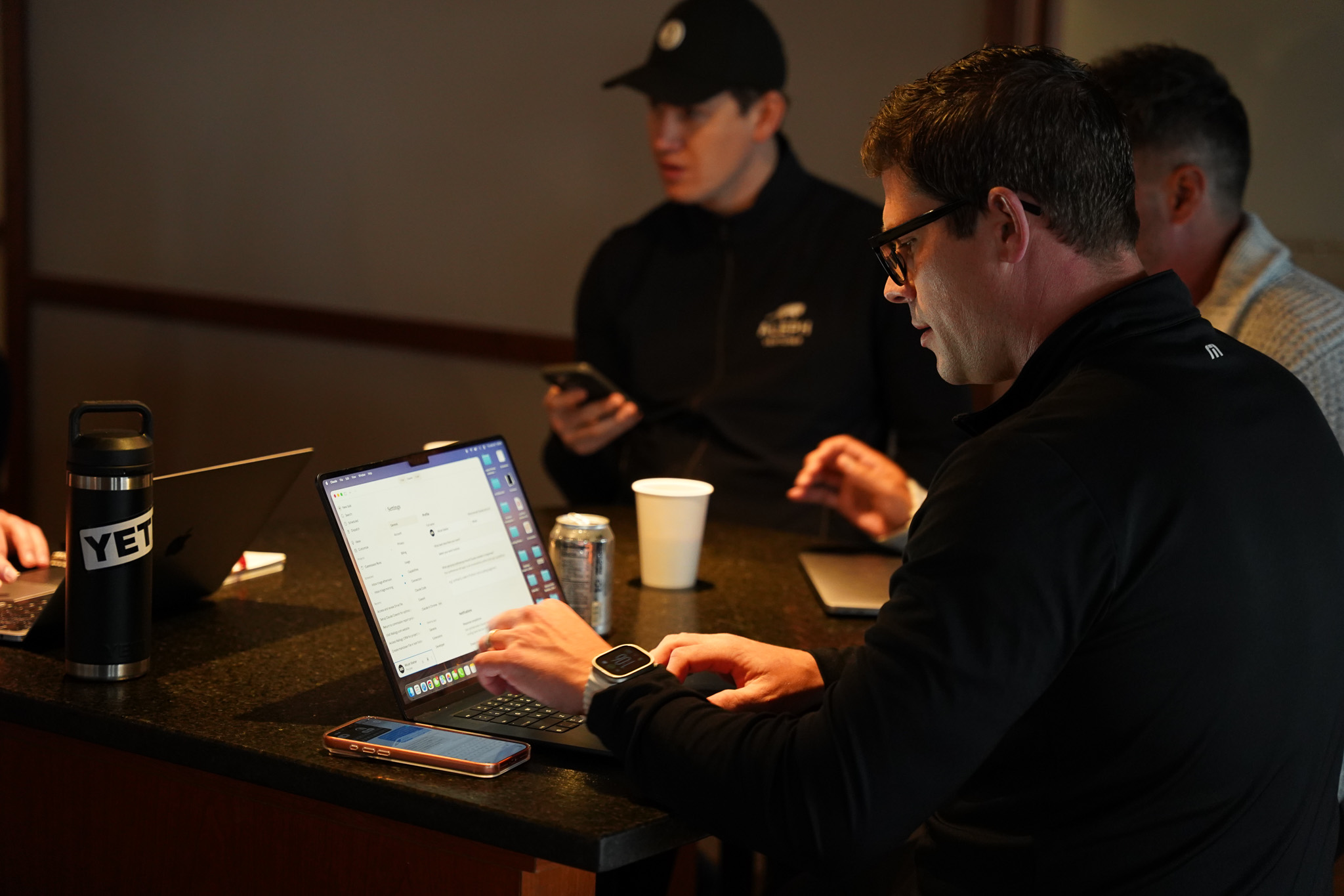 Two people giving a fist bump against a blurred indoor background.