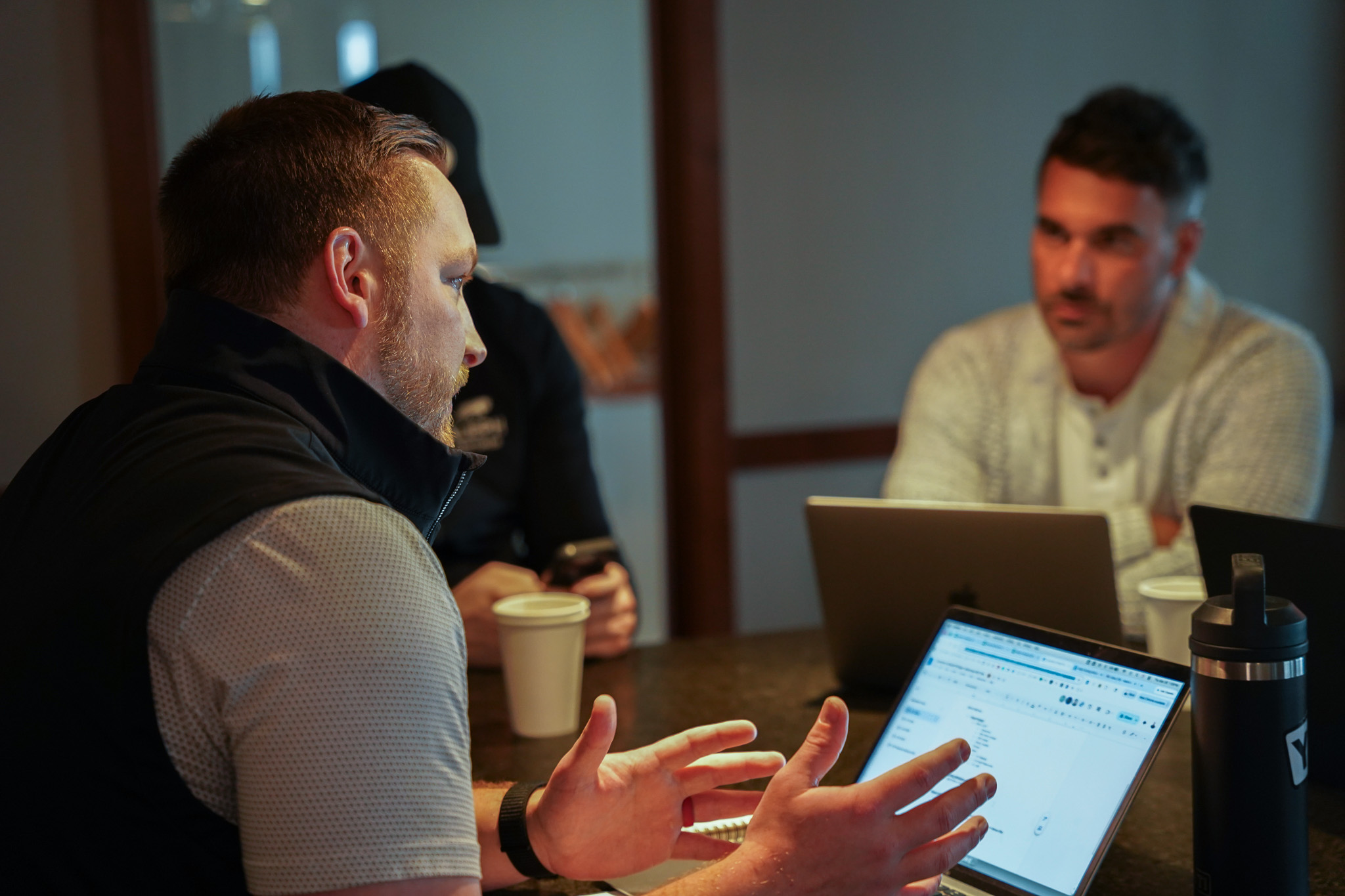 Black geometric bull sculpture on a reflective surface with a blurred background.