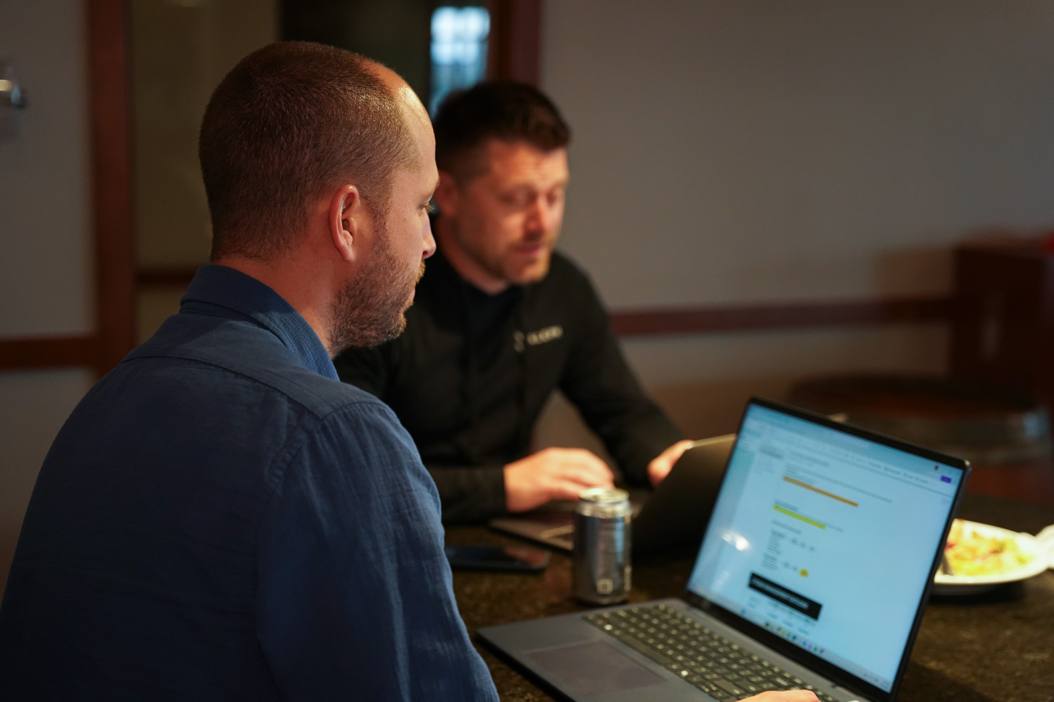 Two people giving a fist bump against a blurred indoor background.