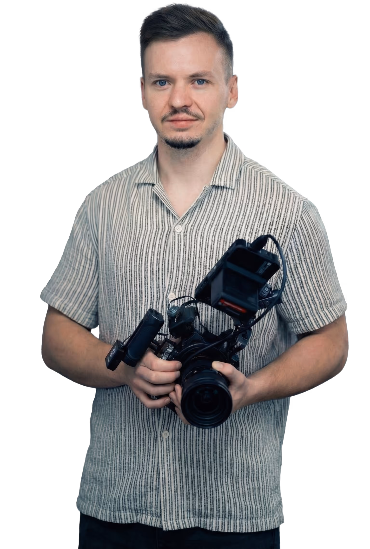 Man in a striped short-sleeve shirt holding a professional video camera.