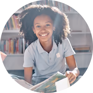 Smiling student reading a book in the school library