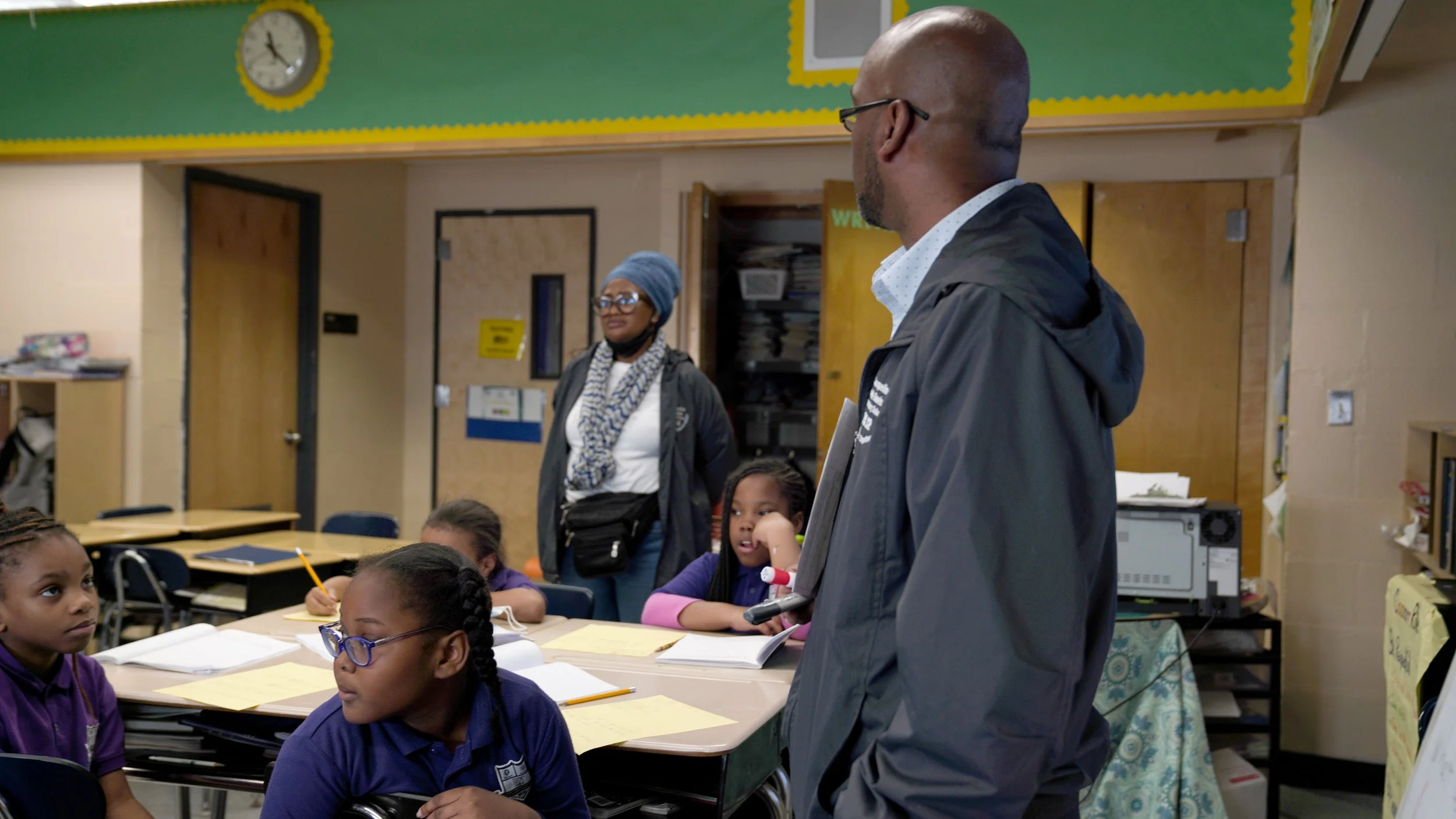 Large group of diverse people posing on a stage decorated with colorful paper