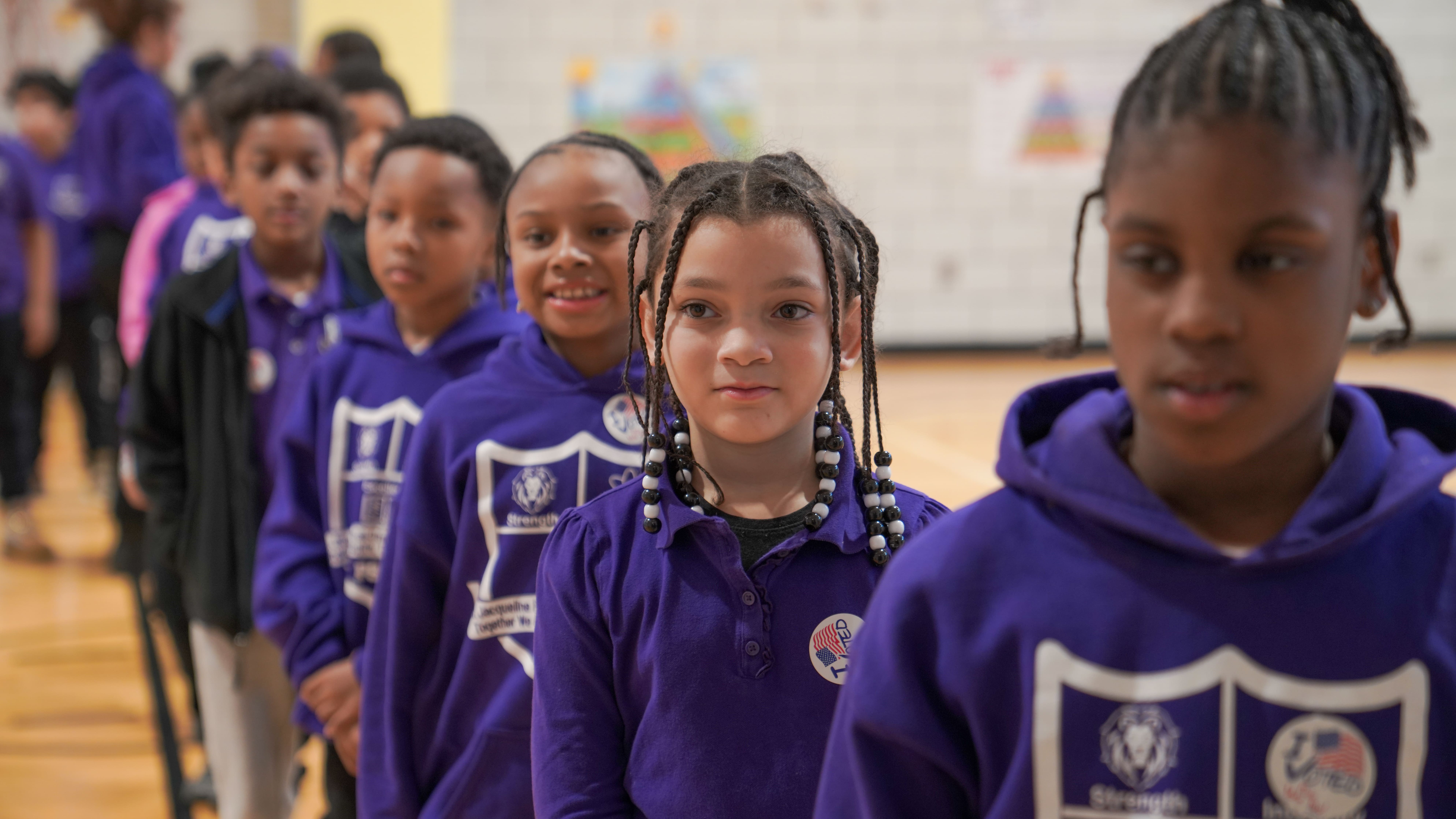 A teacher attentively helps a young boy 