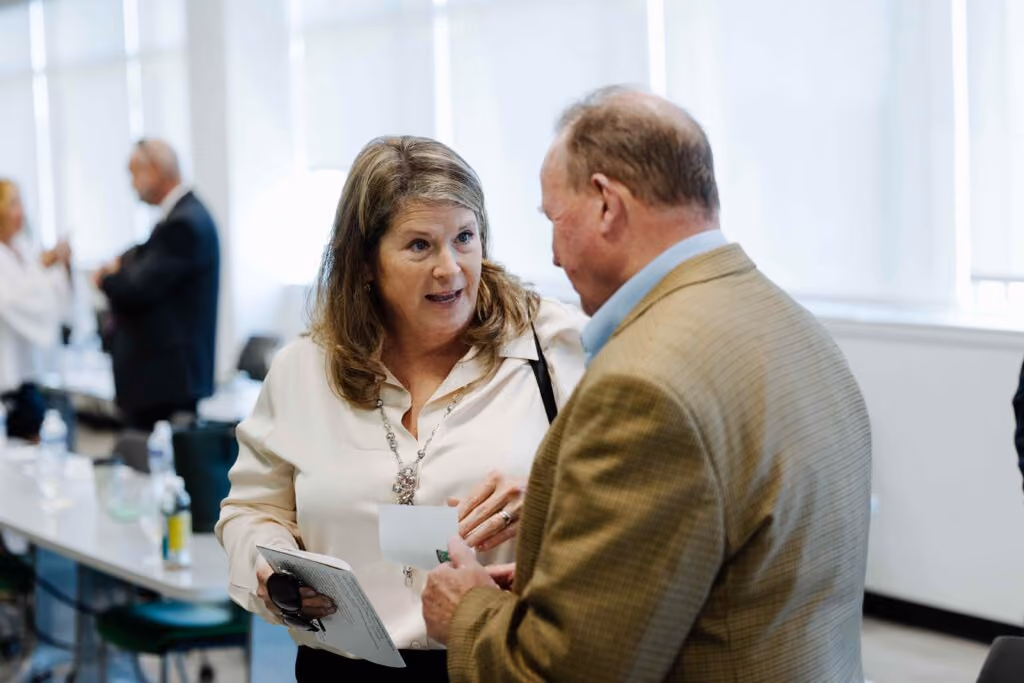 Two people talking on the side after a presentation.