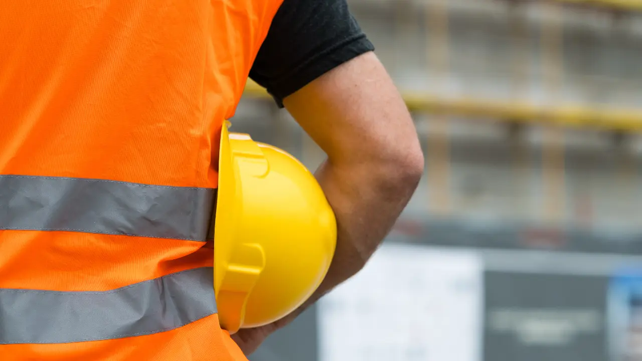 person holding a hard hat wearing a high vis